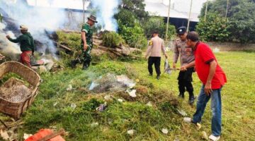 Personel Polsek Madat dan Warga Kompak Gotong Royong Bersihkan Makam