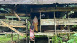 Foto: Kartini Bersama Anaknya Berdiri Didepan Gubuk Derita di Gampong Alue Bieng