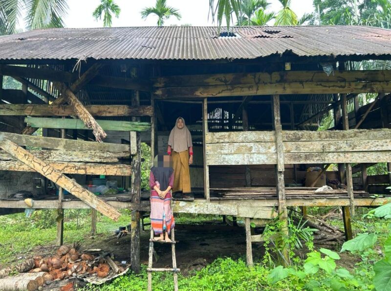 Foto: Kartini Bersama Anaknya Berdiri Didepan Gubuk Derita di Gampong Alue Bieng